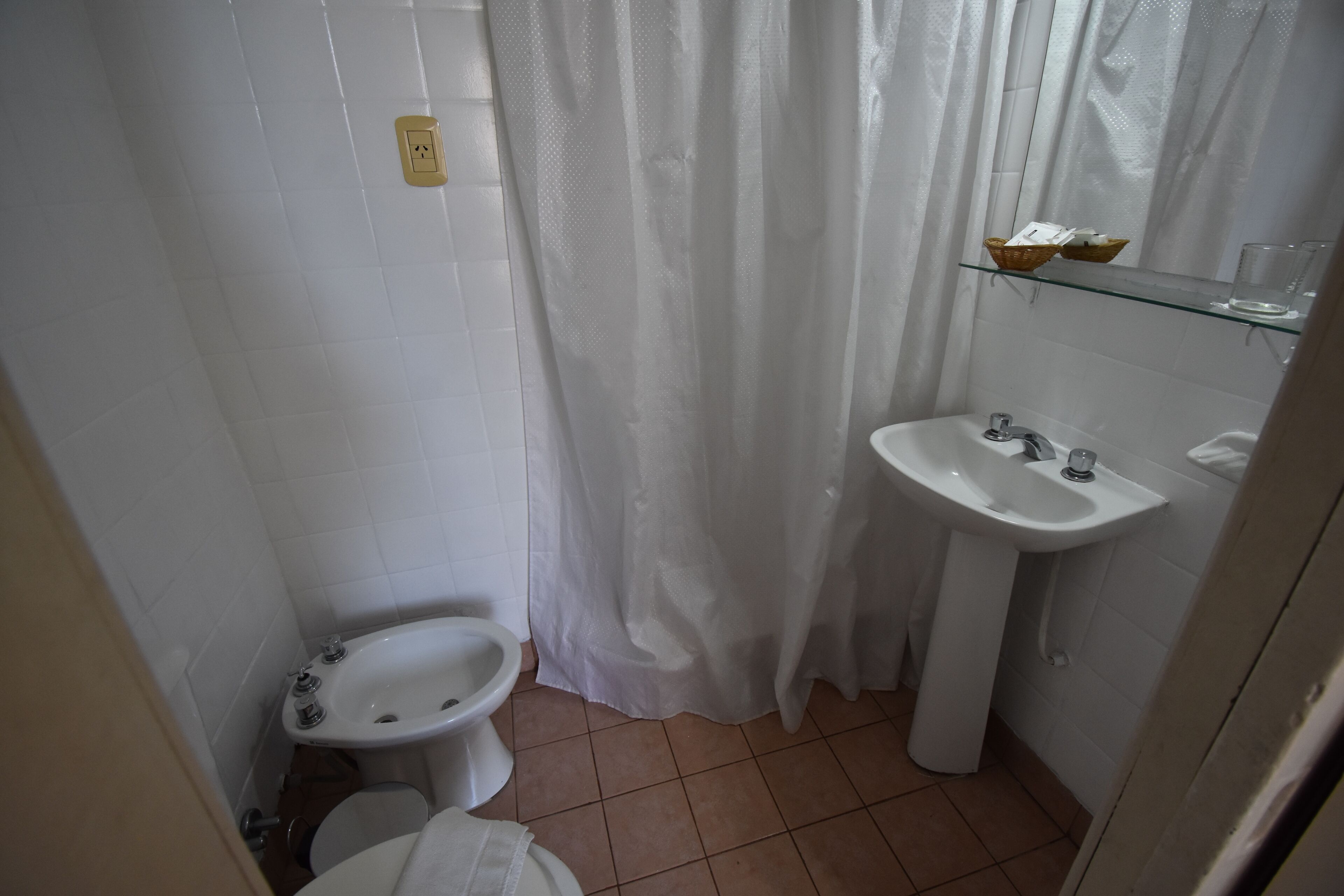 A small bathroom with a toilet, bidet, and sink.
