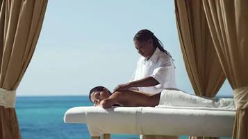 Experience a serene massage on the beach, surrounded by calming ocean views.