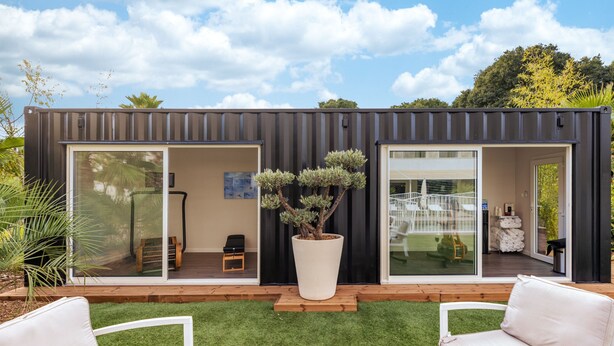 A modern container home with sliding glass doors, a small patio with white furniture, and a large potted tree. - AC Hotel by Marriott Marseille Prado Velodrome (Marseille)