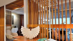 A modern interior with a wooden partition, a white decorative fan, and a magazine on a wooden table. - AC Hotel by Marriott Marseille Prado Velodrome (Marseille)