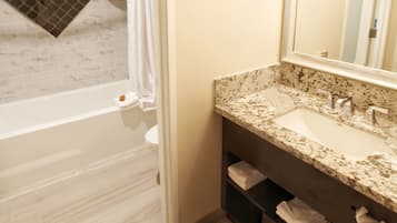 A bathroom with a bathtub, a sink, a mirror, and a shower curtain.