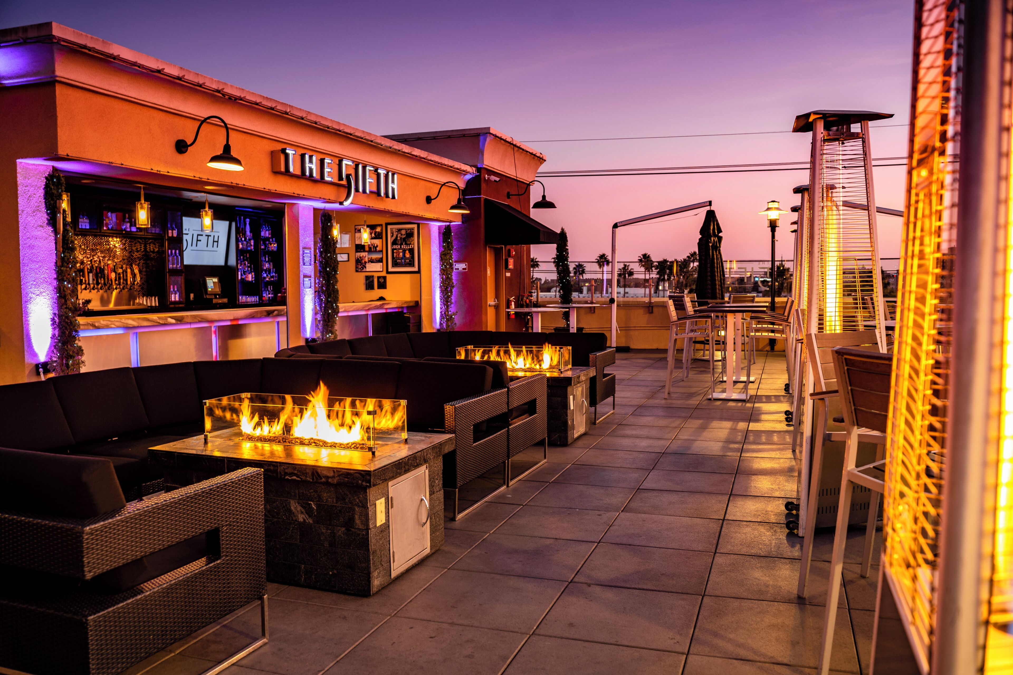 An outdoor bar area with seating and a fire feature.