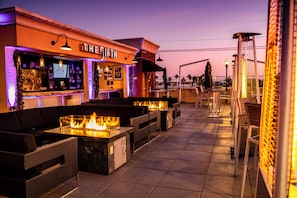 An outdoor bar area with seating and a fire feature. - Grand Legacy At the Park (Anaheim)