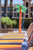 Una piscina al aire libre, sombrillas, sillones reclinables de piscina