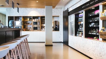 Una cocina moderna con armarios blancos, una isla central y taburetes de bar.
