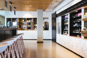 Una cocina moderna con armarios blancos, una isla central y taburetes de bar.