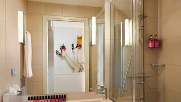 A modern bathroom with a glass shower enclosure, a white sink, and a mirror.