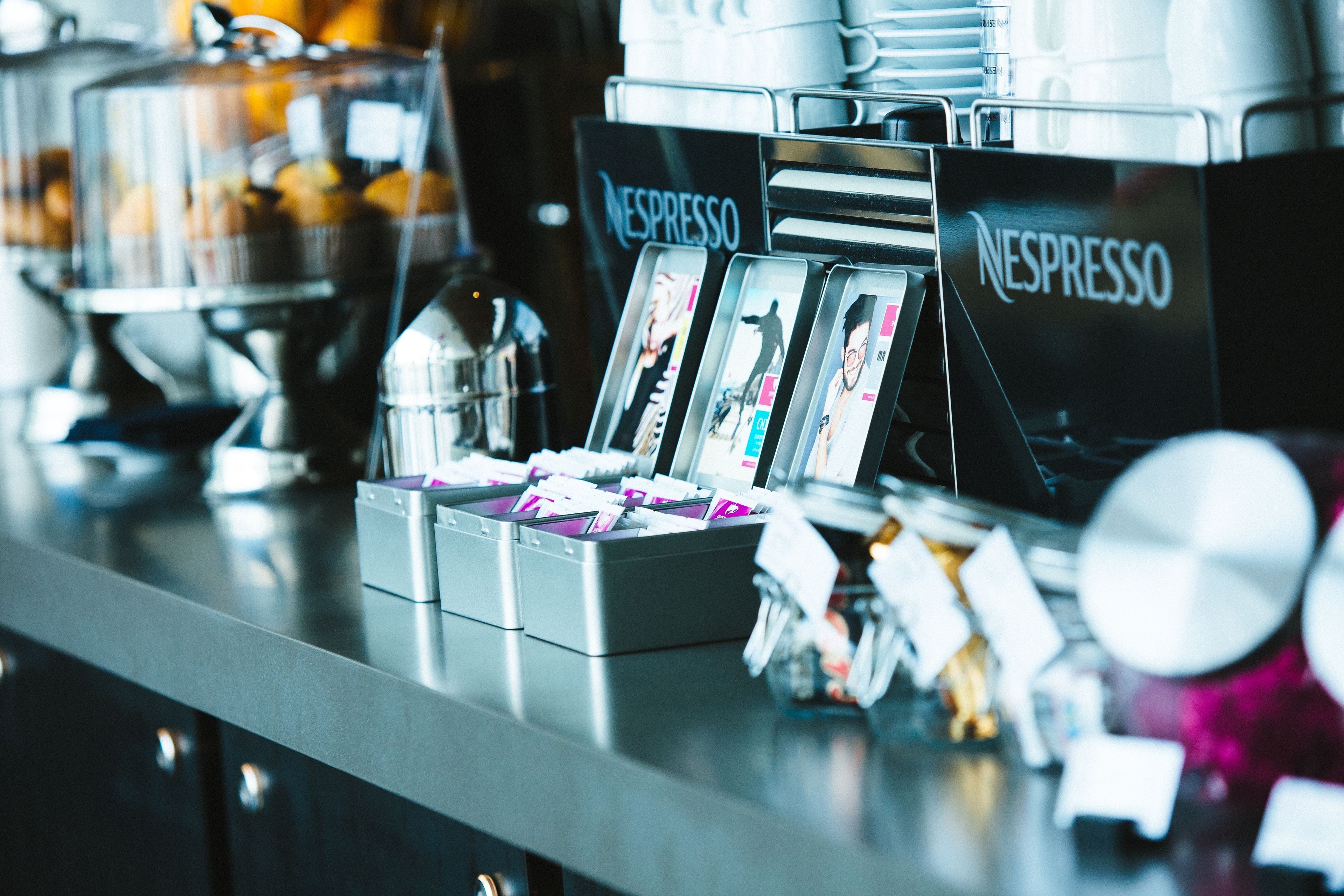 Un angolo caffetteria con diverse macchine Nespresso e una selezione di tazze da caffè.