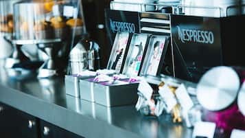 Un angolo caffetteria con diverse macchine Nespresso e una selezione di tazze da caffè.