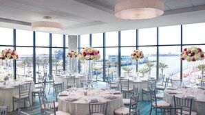 Un espace repas avec des tables rondes, des chaises et des centres de table floraux.
