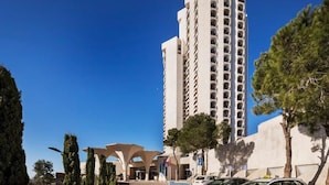 Ein hohes, mehrstöckiges Hotel mit modernem Design, mit Balkonen auf jeder Etage.