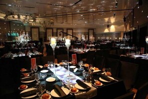 A restaurant with multiple tables set for dining, each with a candle centerpiece. - Vert Jerusalem (Jerusalem)