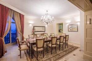 A dining room with a chandelier, a large window with curtains, a dining table set for six, and a view of the city. - Vert Jerusalem (Jerusalem)