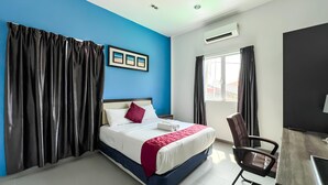 A hotel room with a bed, a desk, a chair, a window, and an air conditioning unit. - Royal Agate Beach Resort (Langkawi)