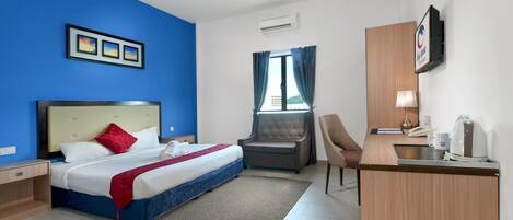 A hotel room with a bed, a desk, a chair, and a window with curtains.