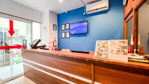 A reception desk with a computer, a television mounted on the wall, and framed certificates. - Royal Agate Beach Resort (Langkawi)