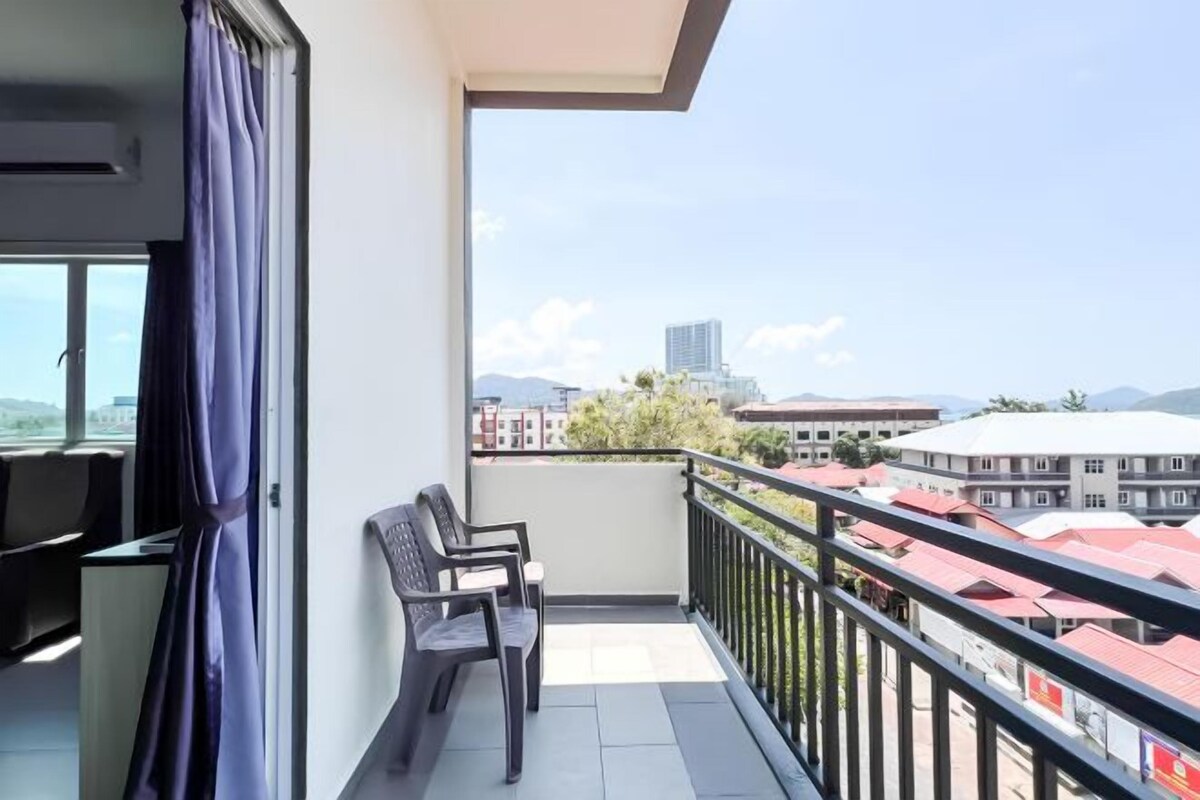 A balcony with a view of buildings and mountains.