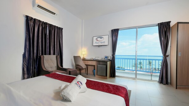 A hotel room with a bed, a desk, a chair, and a view of the sea. - Royal Agate Beach Resort (Langkawi)