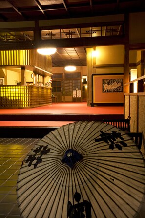 A traditional Japanese interior with tatami flooring, a low table, and a decorative fan with calligraphy. - Okutsuso (Kagamino)