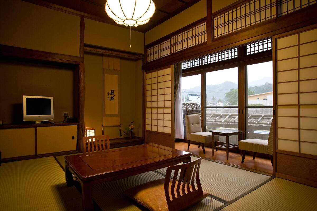 A traditional Japanese room with tatami flooring, a low table, and sliding doors.