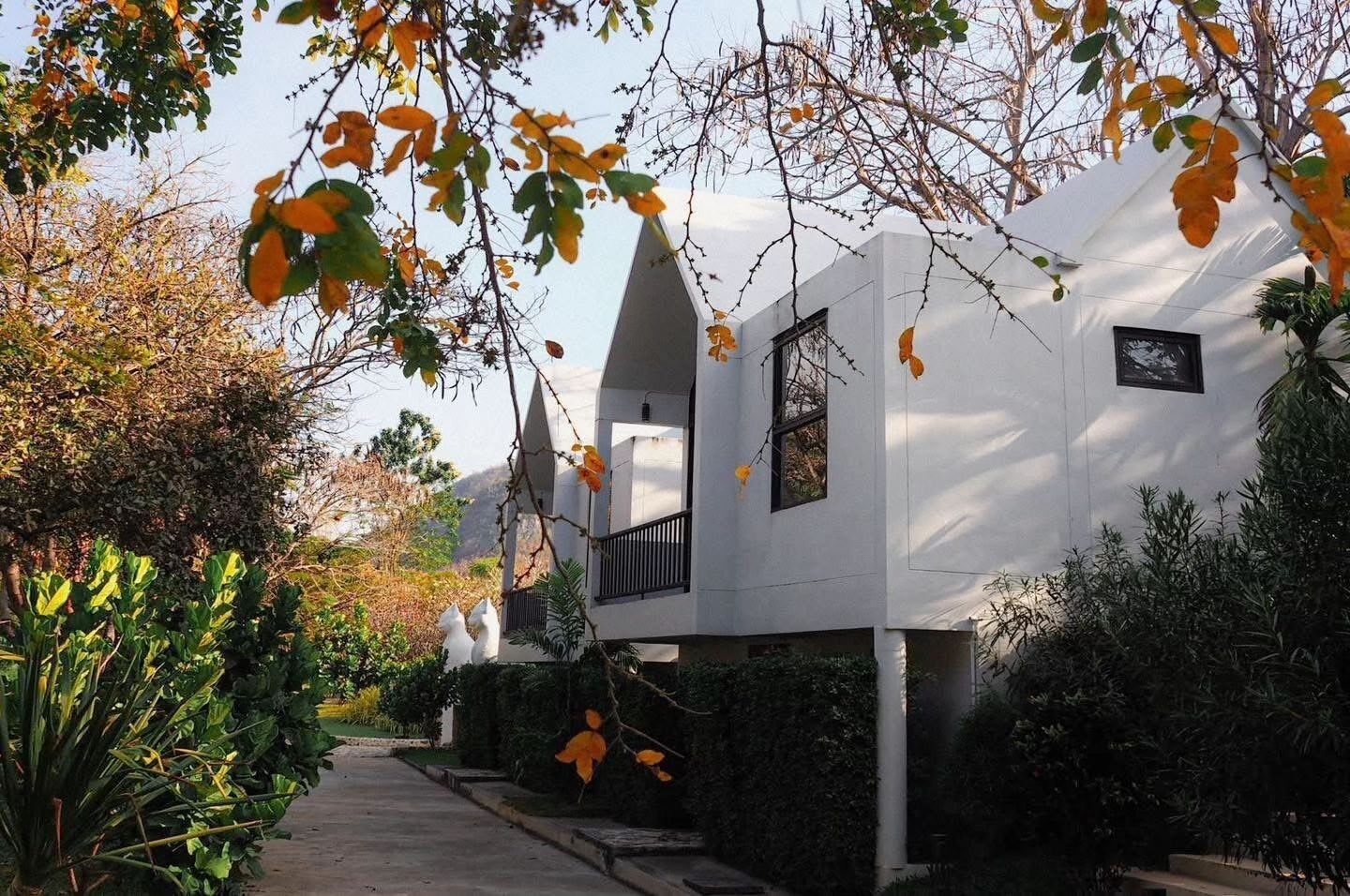 Um edifício moderno com design arquitetônico único, apresentando uma varanda e uma pequena janela.