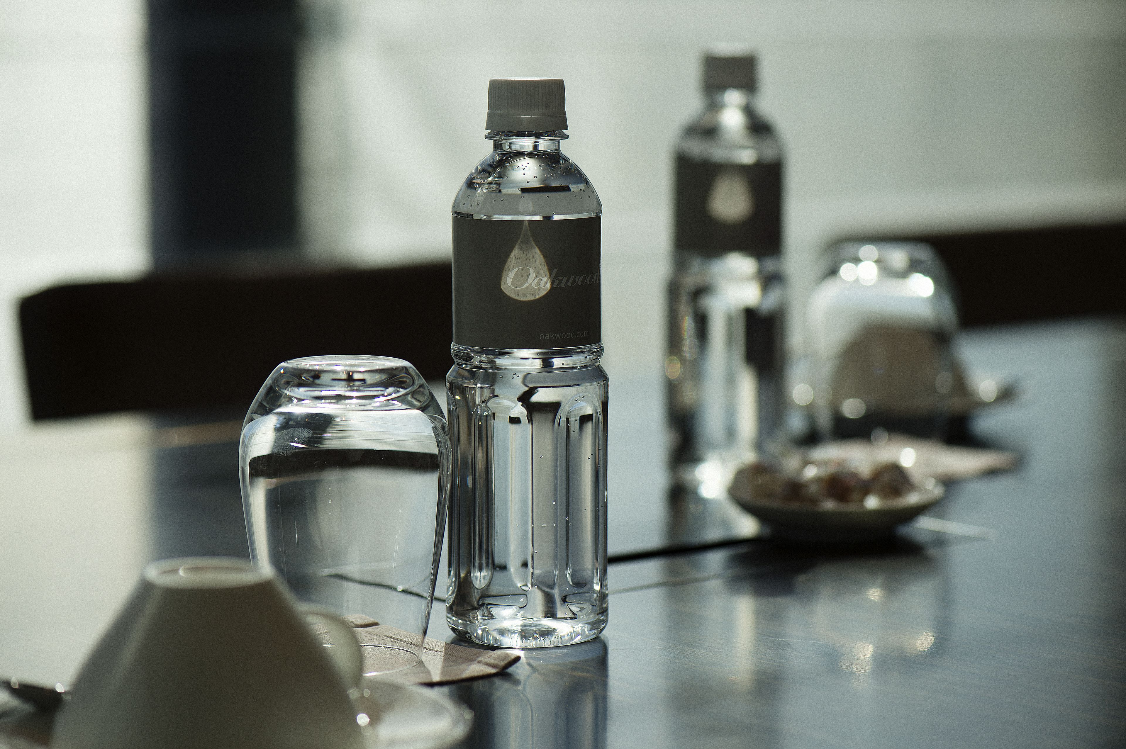 A table with clear glass bottles and a pitcher, likely containing water, in a modern setting.