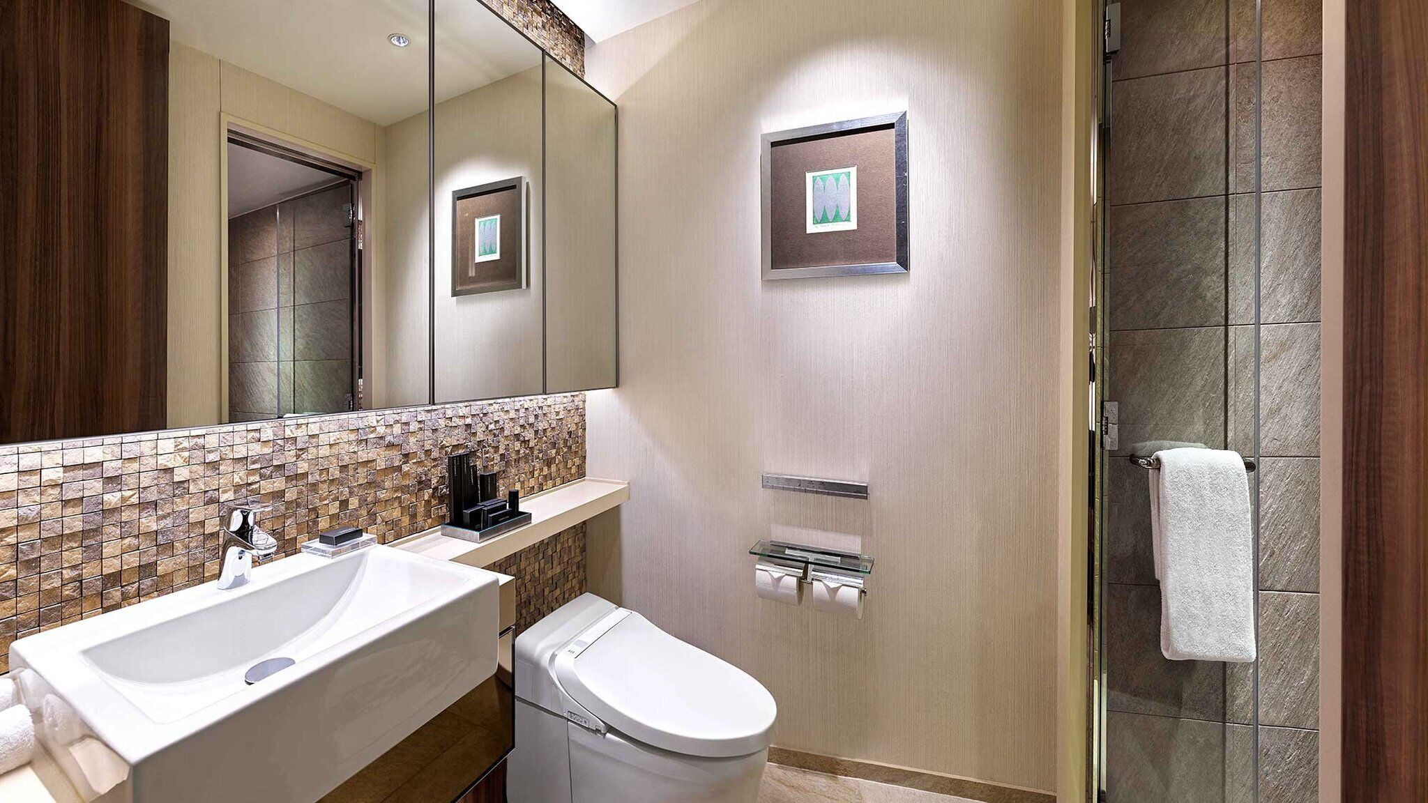A modern bathroom with a large mirror, a sink, a toilet, and a shower area.