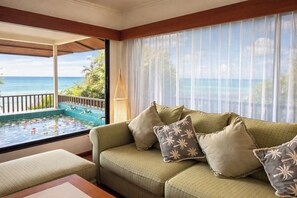 A balcony with a pool, a sofa with patterned cushions, and a view of the sea. - Birds and Bees Resort (Pattaya)
