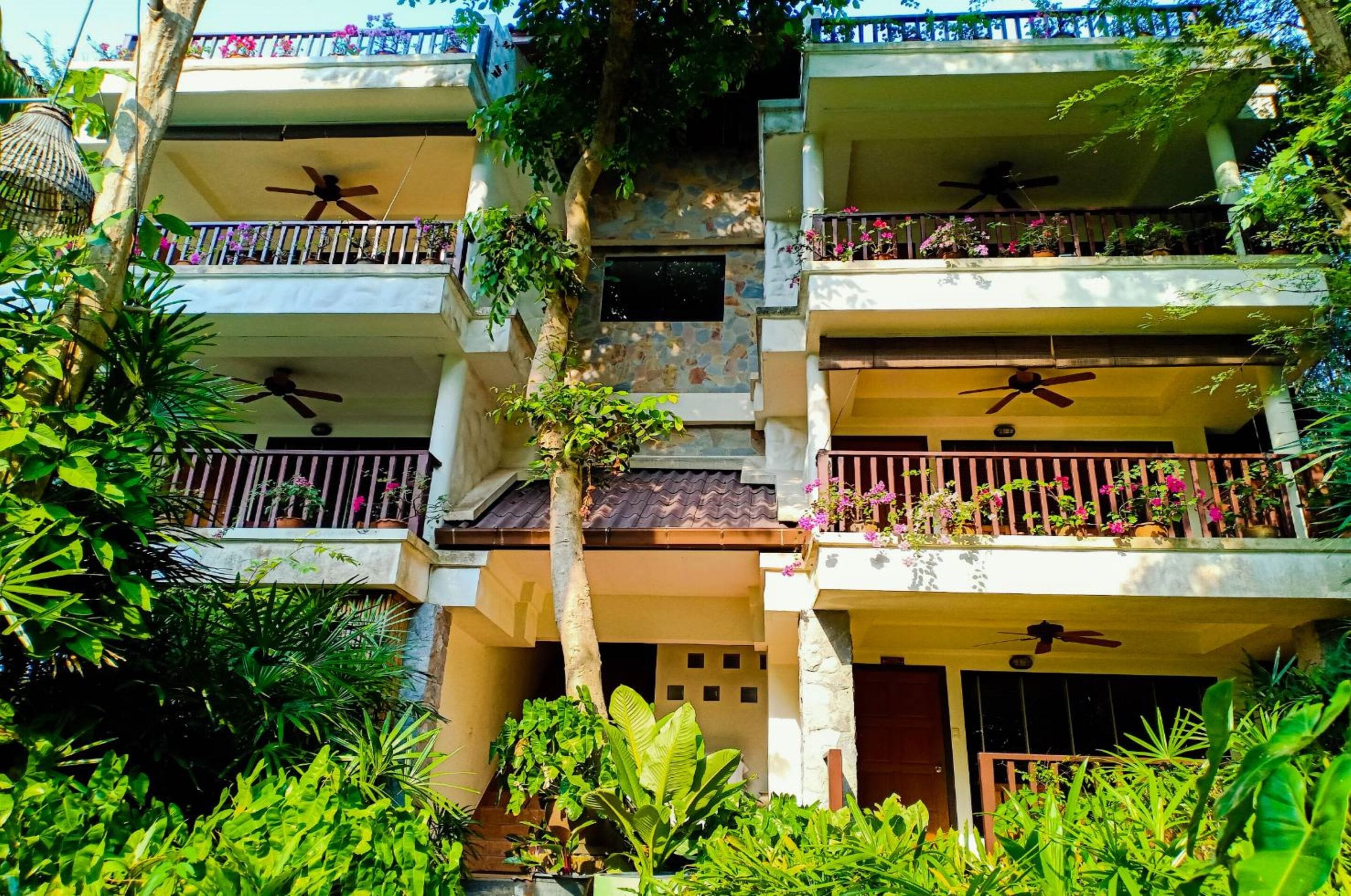 Un edifici residencial de diverses plantes amb balcons, cadascun equipat amb un ventilador de sostre.