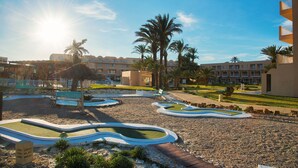 A resort with a pool area, palm trees, and a building with multiple balconies. - AQI Skanes Resort (Monastir)
