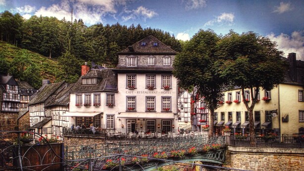 A historic building with a café, restaurant, and hotel. It features a stone bridge and cobblestone streets. - Hotel Horchem (Monschau)