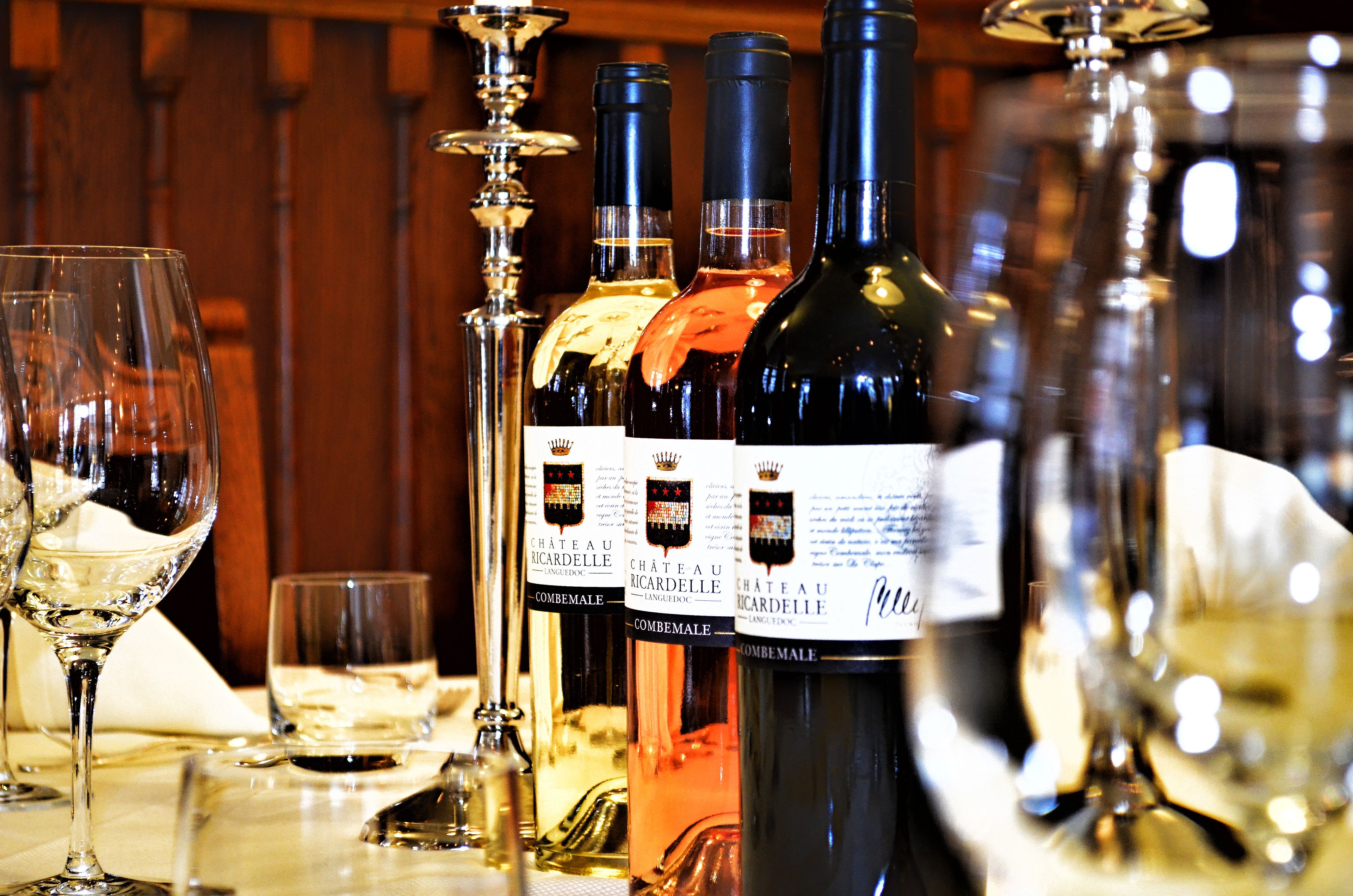 A bar setting with bottles of wine and glasses.