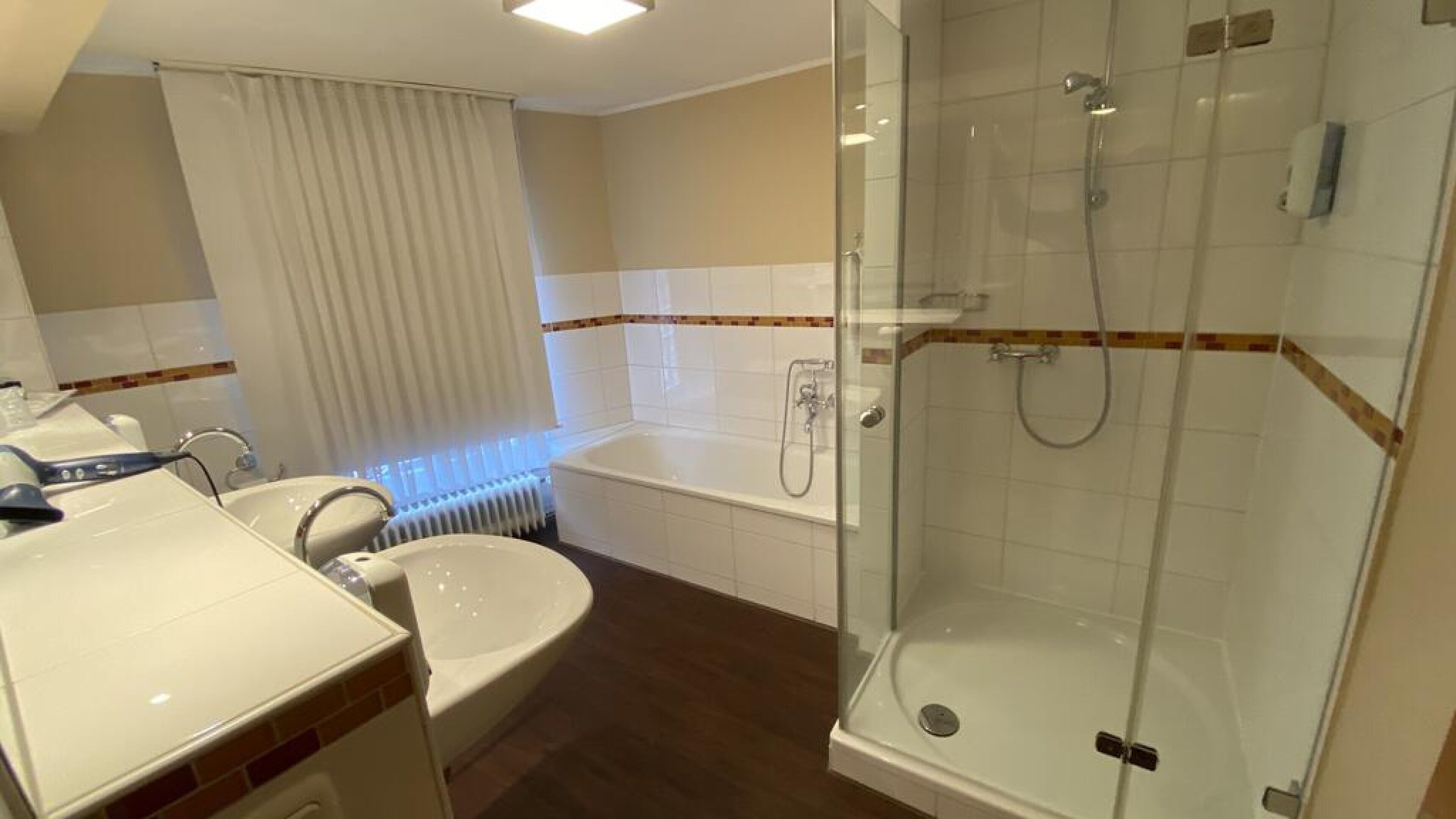 A modern bathroom with a bathtub, a shower, and a sink.