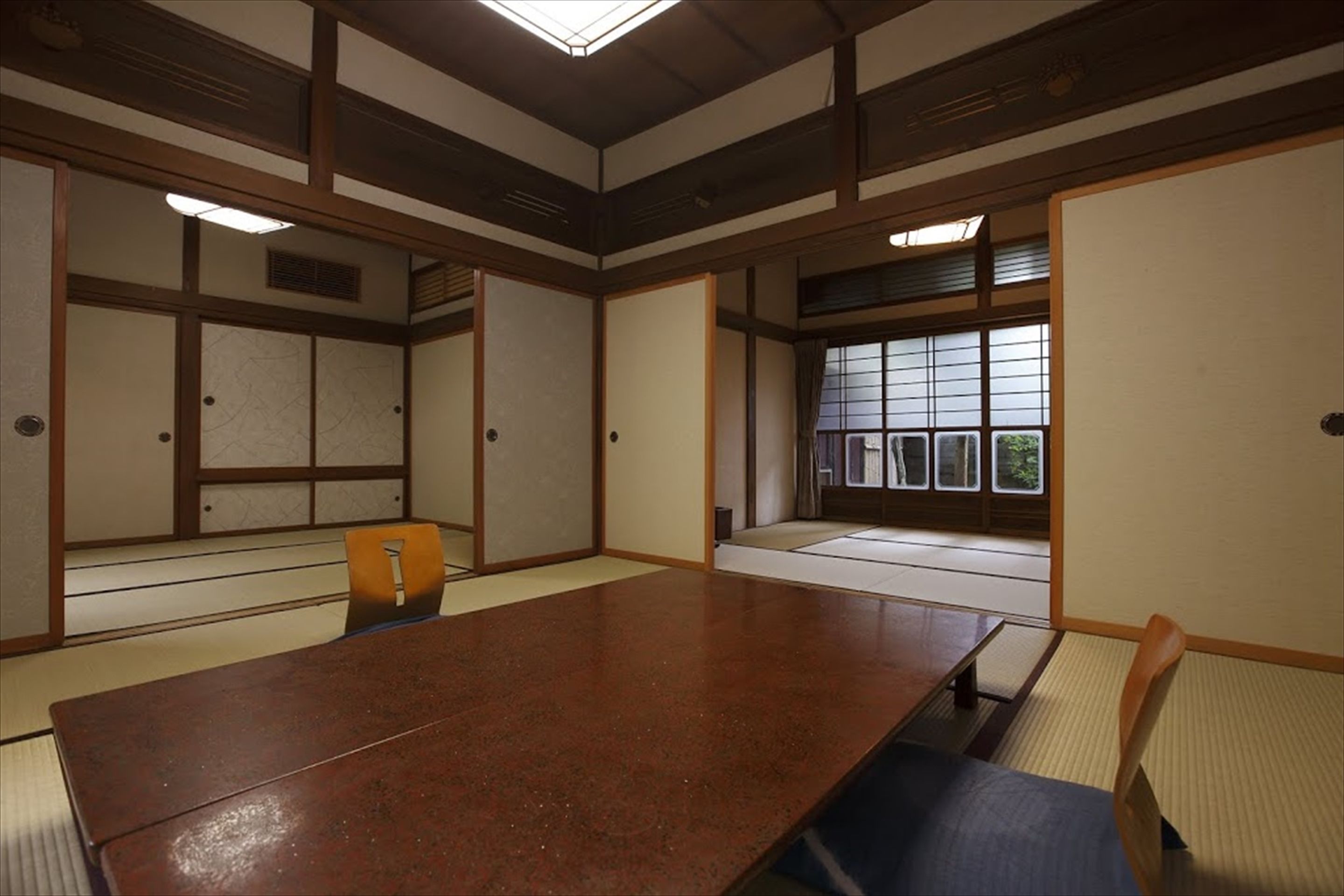 A traditional Japanese room with tatami flooring, a low wooden table, and sliding shoji doors.