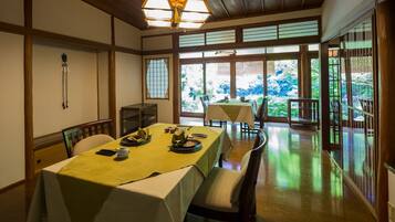 A traditional Japanese-style dining room with tatami mats, low tables, and sliding doors.