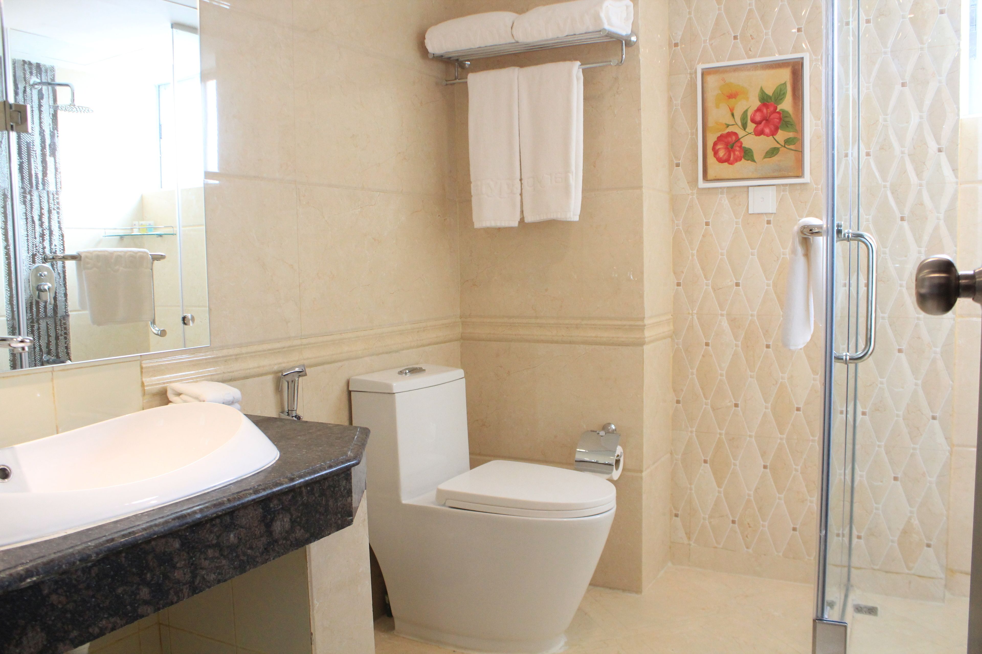 Un baño con lavamanos, inodoro y ducha.