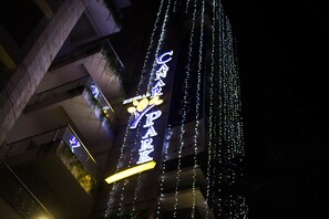 Un bâtiment doté d’une enseigne lumineuse indiquant « CINNAMON PARK » et décoré de guirlandes lumineuses.