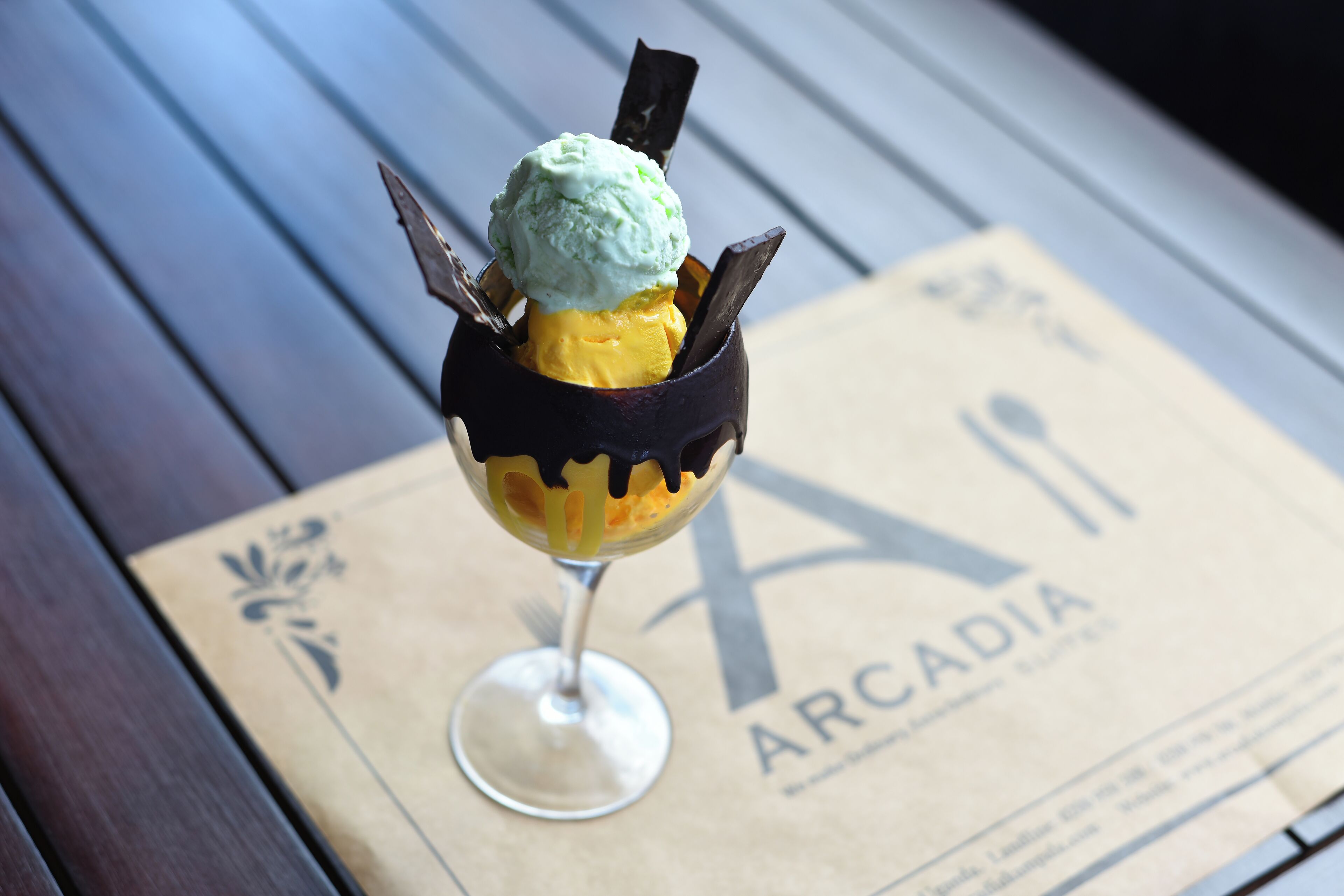 Un postre en un vaso sobre una mesa, con un menú de fondo.
