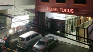 Un edificio de varios pisos con un llamativo letrero que dice 'HOTEL FOCUS'.