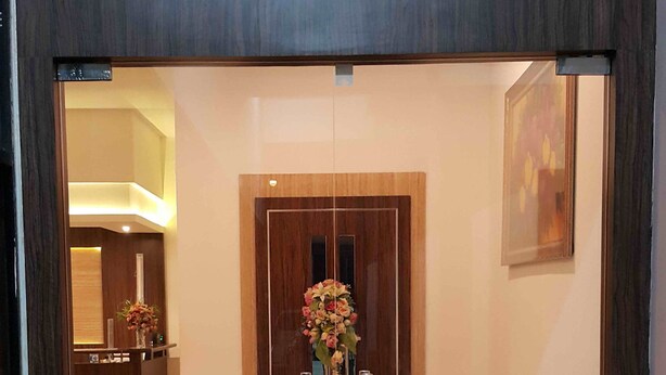 Un área de recepción con un mostrador de madera, un jarrón de flores y un cuadro en la pared.
