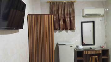 Un baño con cortina de ducha, espejo, aire acondicionado, lavabo e inodoro.