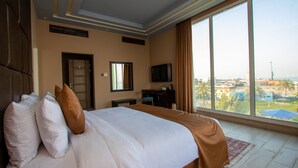 Une chambre d’hôtel avec un grand lit, un bureau, une télévision et une vue sur la ville.