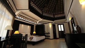 Una habitación de hotel espaciosa con una cama grande, un escritorio y una zona de estar.
