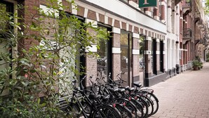 A brick building with a green sign reading "DE PUP BOUTIQUE HOTEL". - De Pijp Boutique Hotel (Amsterdam)
