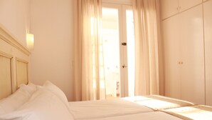 Una habitación de hotel con una cama, un armario y una puerta que da a un baño.