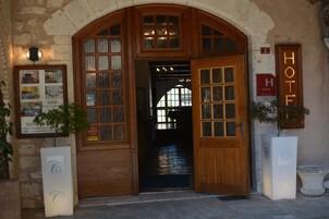 Entrada de un hotel con un arco de madera, un cartel que indica la habitación número 2 y un letrero que dice 'HOTEL'.