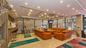 A modern hotel lobby with a large seating area, a staircase, and a bar. - Grand Palace Hotel (Istanbul)