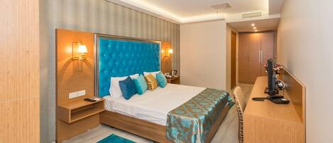 A modern hotel room with a large bed, bedside tables, a desk, and a chair.