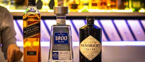 Three bottles of alcohol on a bar counter.