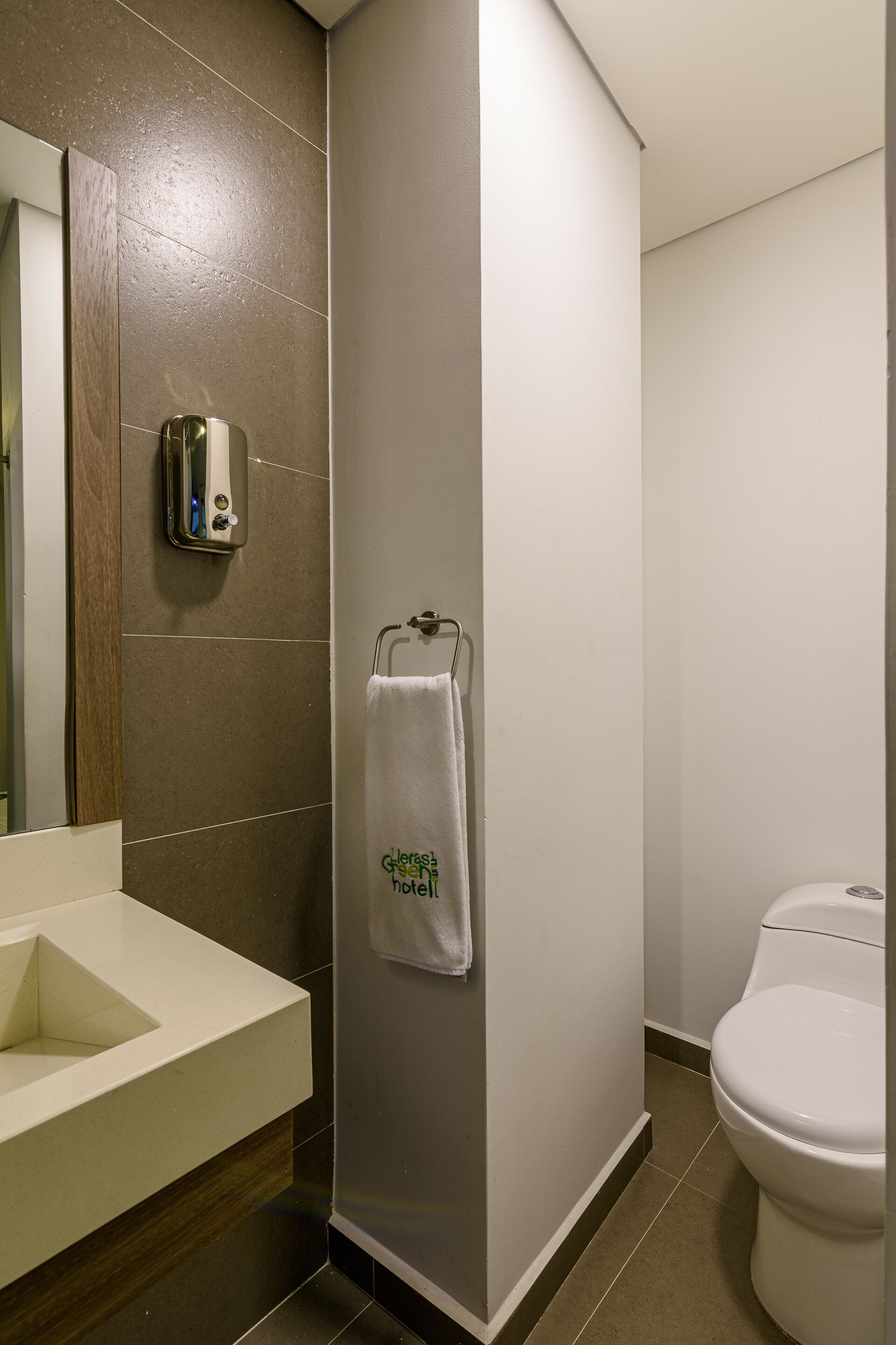 Un baño moderno con un lavamanos blanco, cabina de ducha de vidrio y un inodoro.